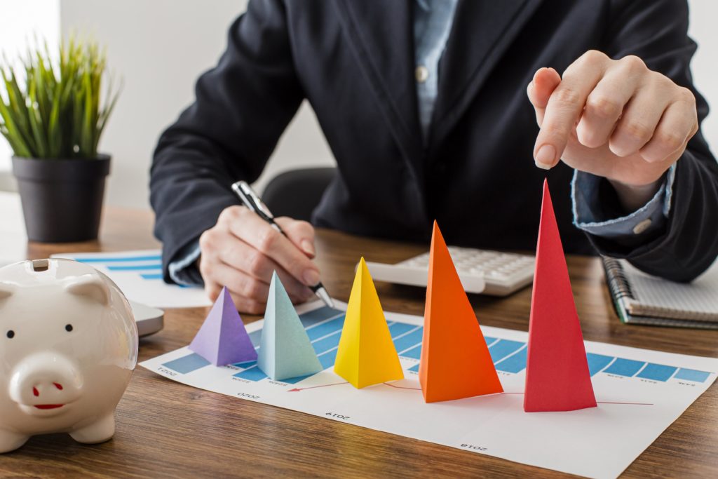 Front View Of Businessman With Colorful Cones Representing Growth - Nuvecon